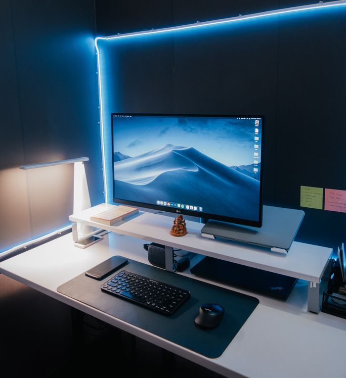 A sleek computer desk setup with LED lighting and a modern aesthetic.