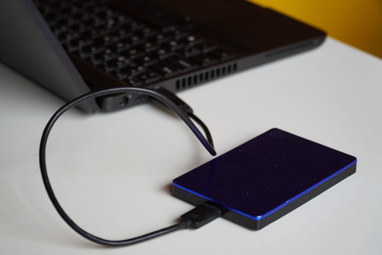 social-feed-img-04 External hard drive connected to a laptop, showcasing portable storage solution.