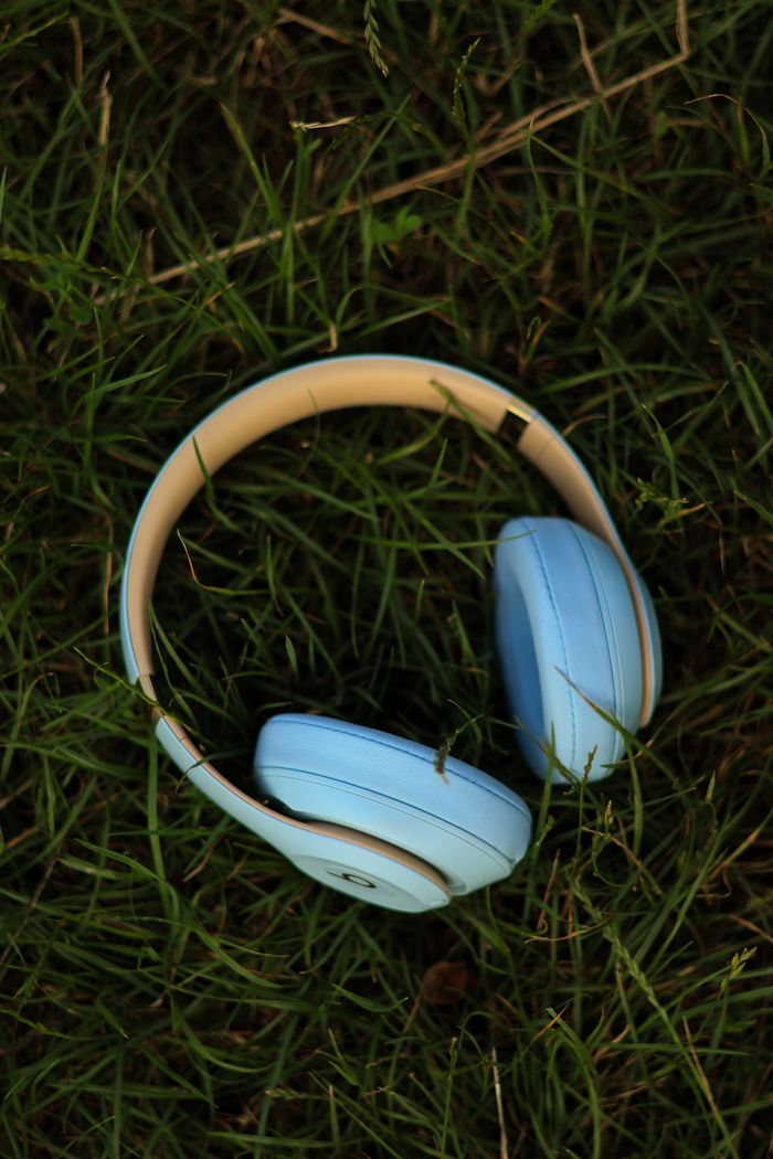 Close-up of blue headphones on grass, symbolizing relaxation and outdoor listening.