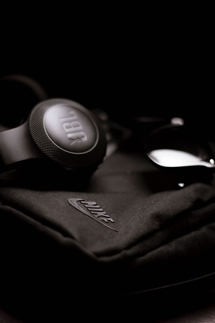 JBL headphones resting on a black Nike bag, showcasing sleek and modern design.