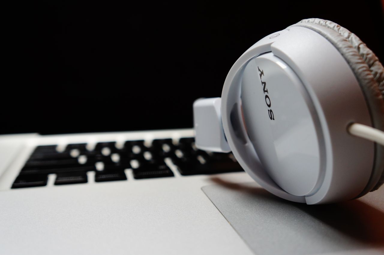 social-feed-img-03 White headphones resting on a laptop keyboard, highlighting modern technology.