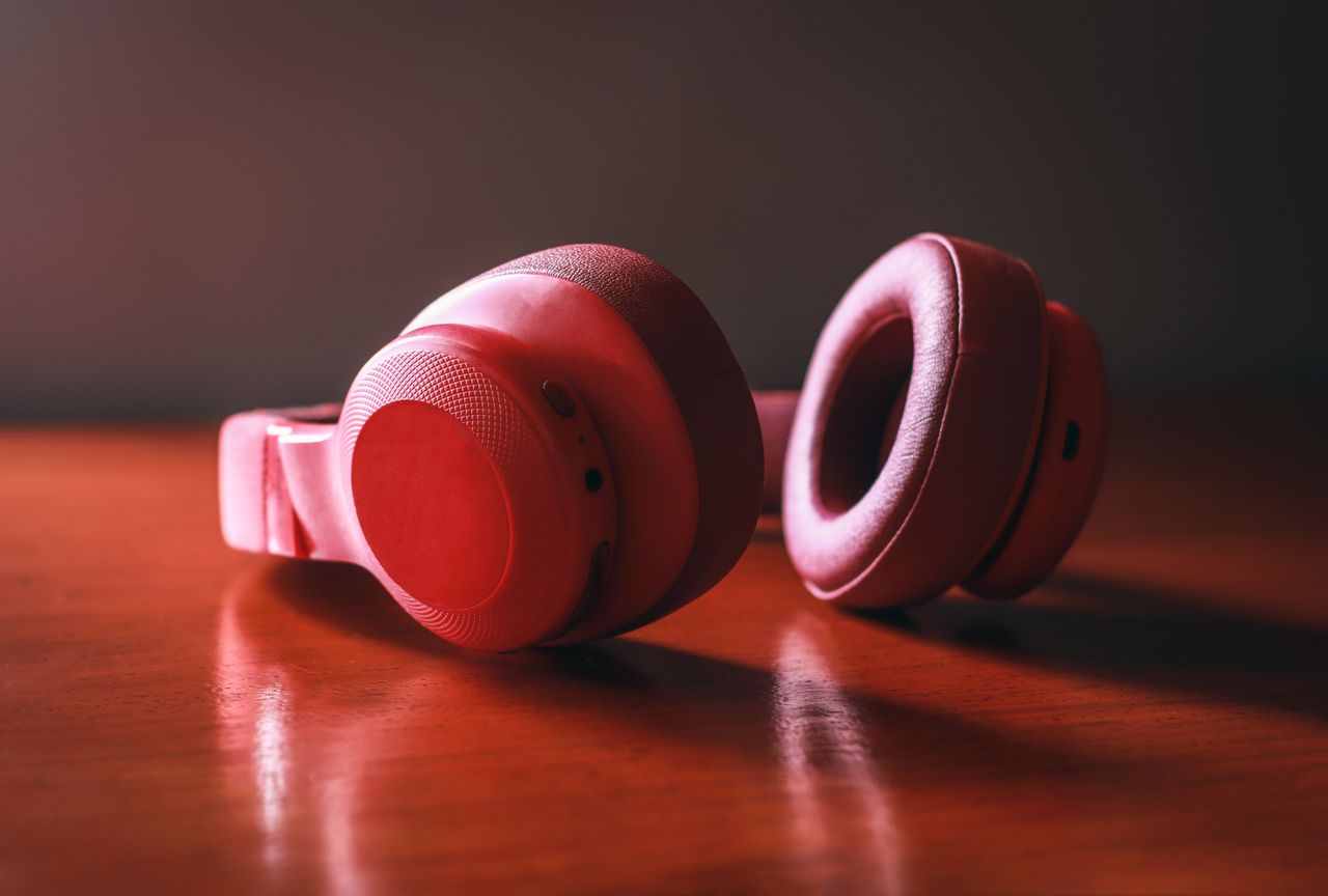 Mastering the First Impression: Your intriguing post title goes here Close-up of red wireless headphones resting on a wooden surface, highlighting sleek design and vibrant color.